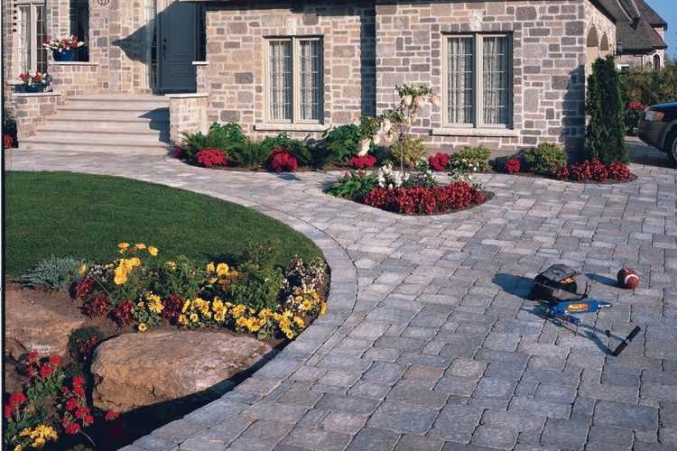 A paver stone driveway leads up to a house