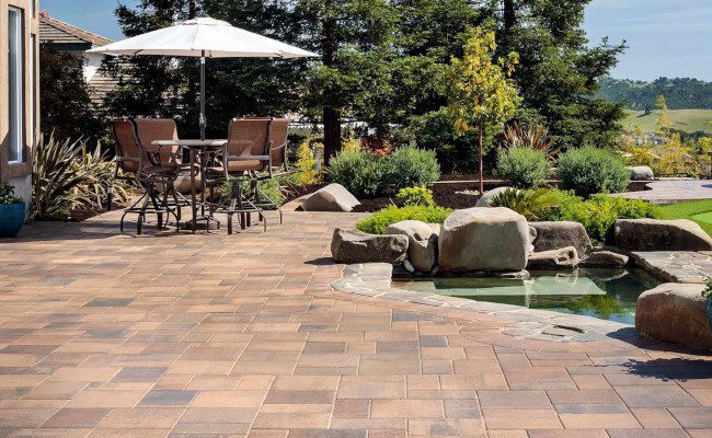 A hardscape patio made with paver stones makes this backyard a true oasis for fun and relaxation