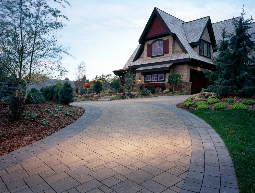 A custom paverstone driveway leading up to a house