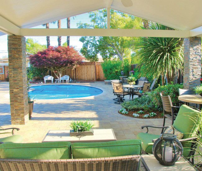 A hardscape patio made with paver stones makes this backyard a true oasis for fun and relaxation