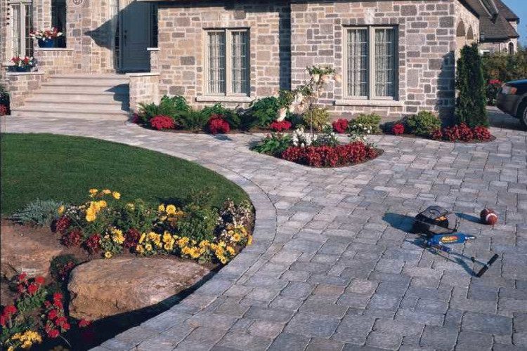 A paver stone driveway leads up to a house