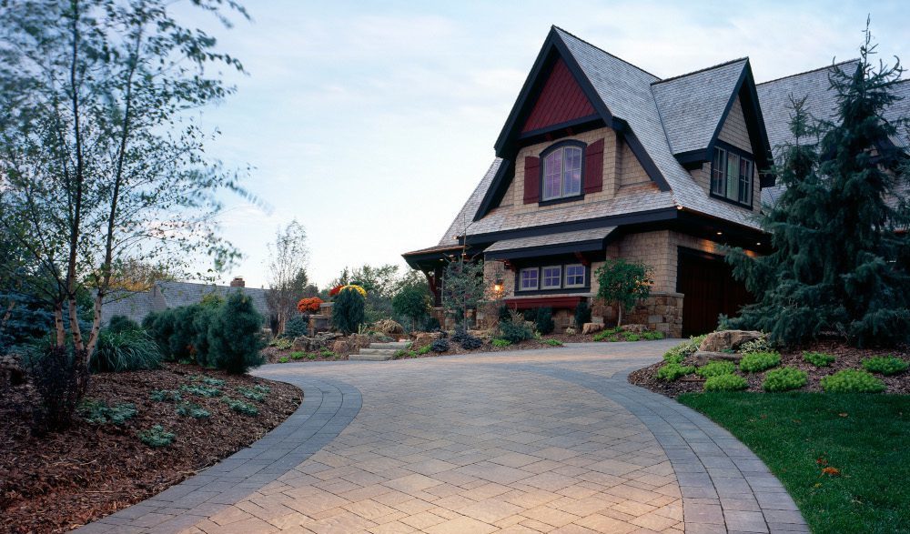 A custom paverstone driveway leading up to a house