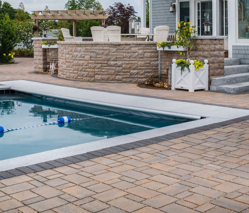 A swimming pool with a paver stone pool deck makes this backyard the envy of the neighborhood