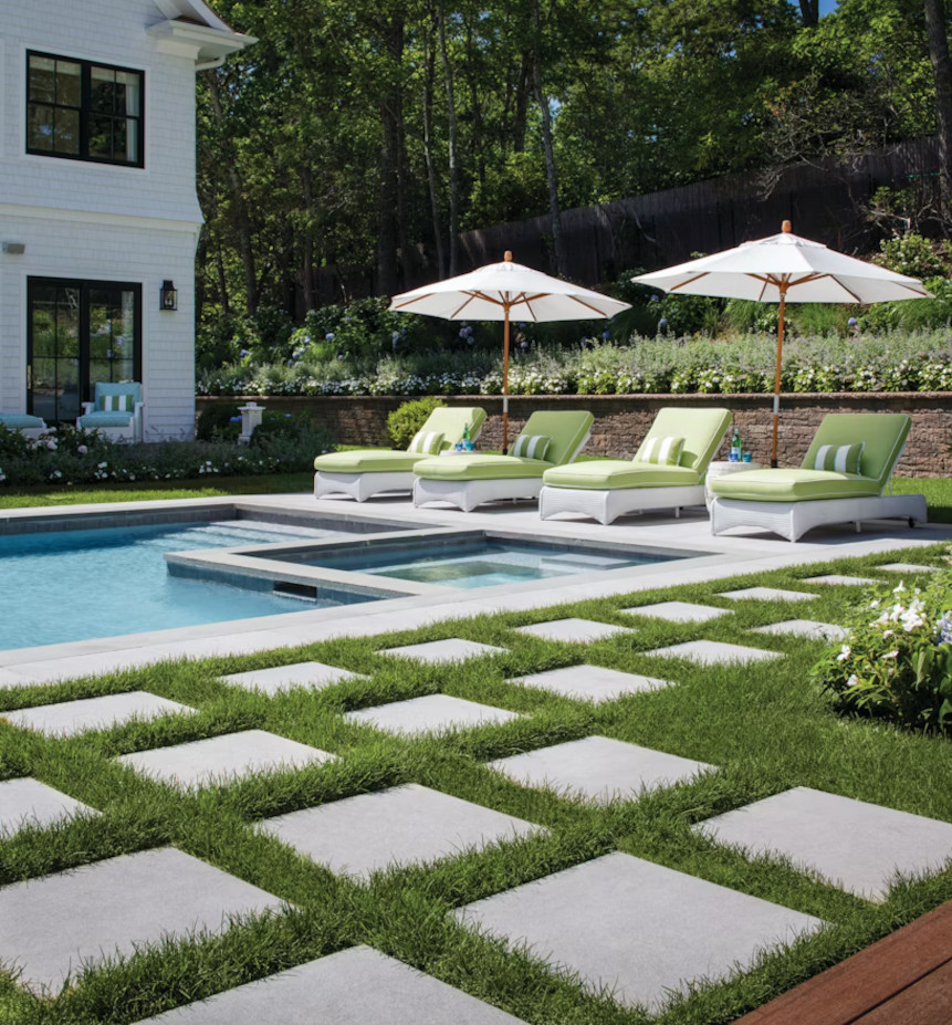 A custom swimming pool with paver stones and artificial grass