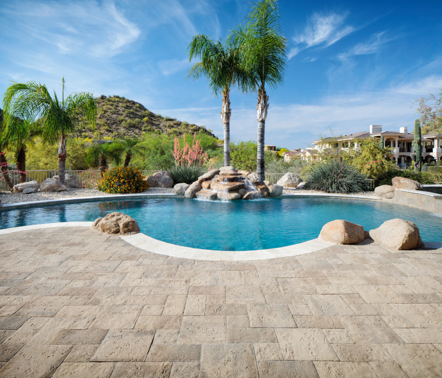 A swimming pool with a paver stone pool deck makes this backyard the envy of the neighborhood